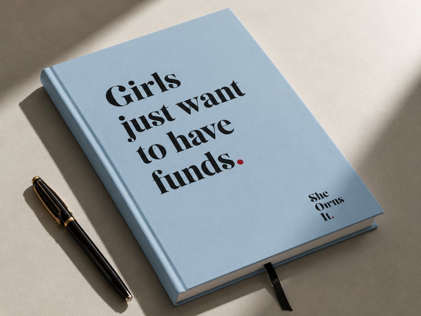 Lyseblå notatbok med teksten «Girls just want to have funds.»